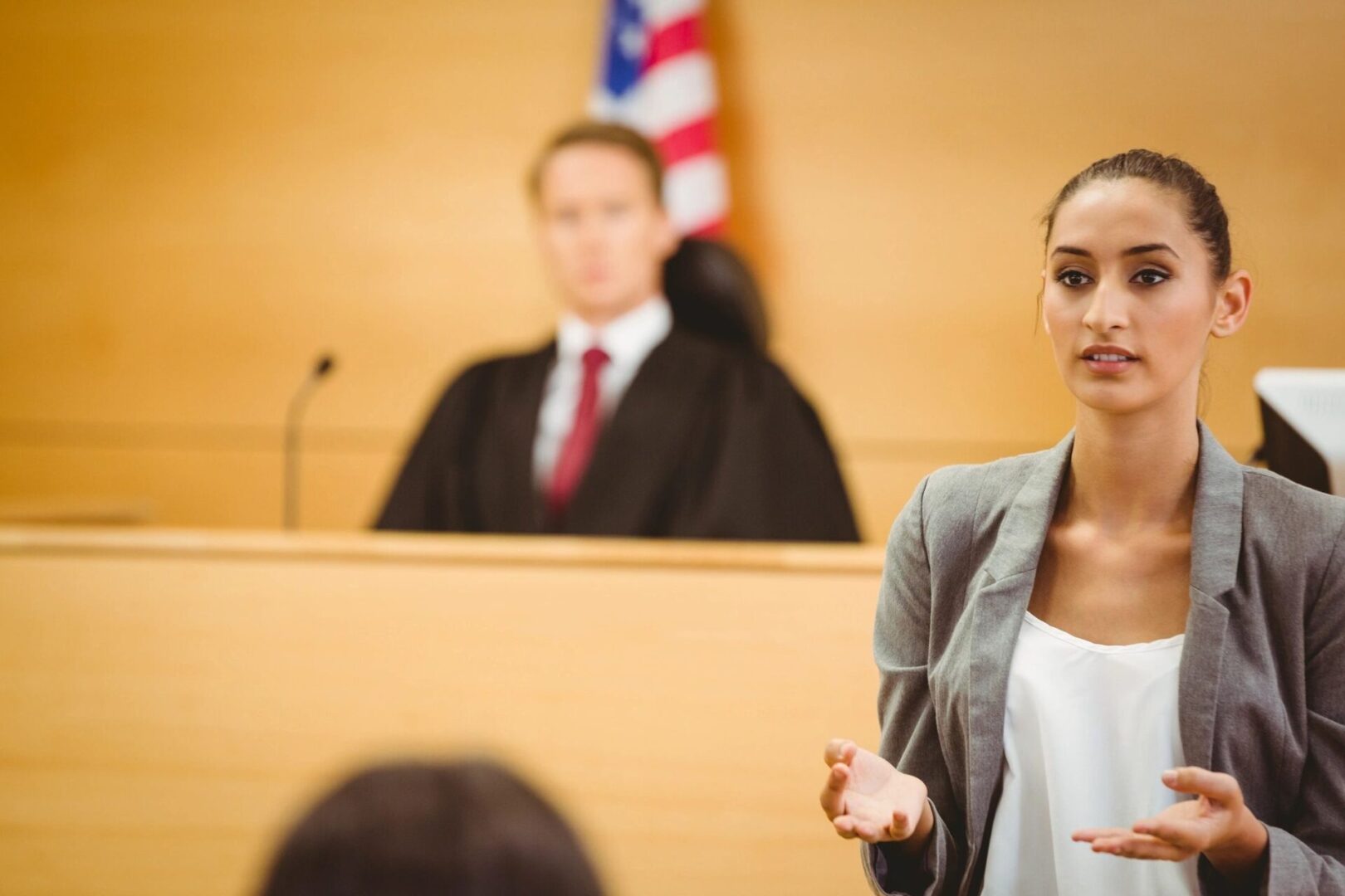 A woman in front of judge and courtroom