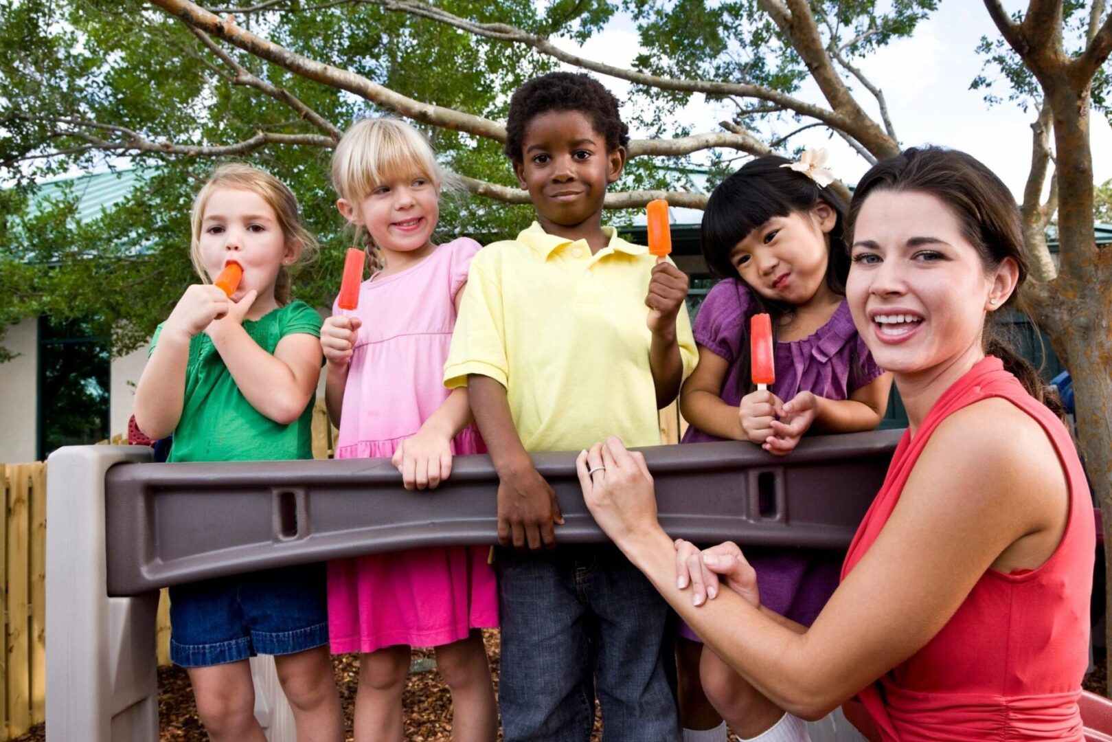 A group of children holding popsicles and posing for the camera.